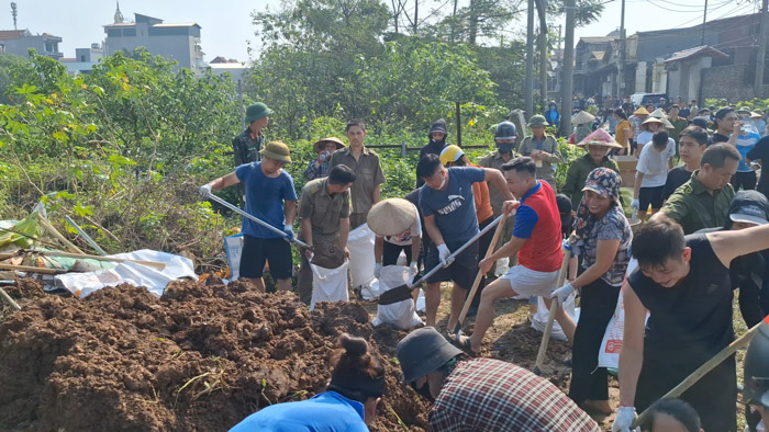 Lực lượng chức năng và người dân đóng cọc bê tông, cọc tre, thả hộc bê tông, bao tải đất, rọ đá… khắc phục sự cố công trình thủy lợi trên đê sông Ngũ Huyện Khê ở Bắc Ninh.