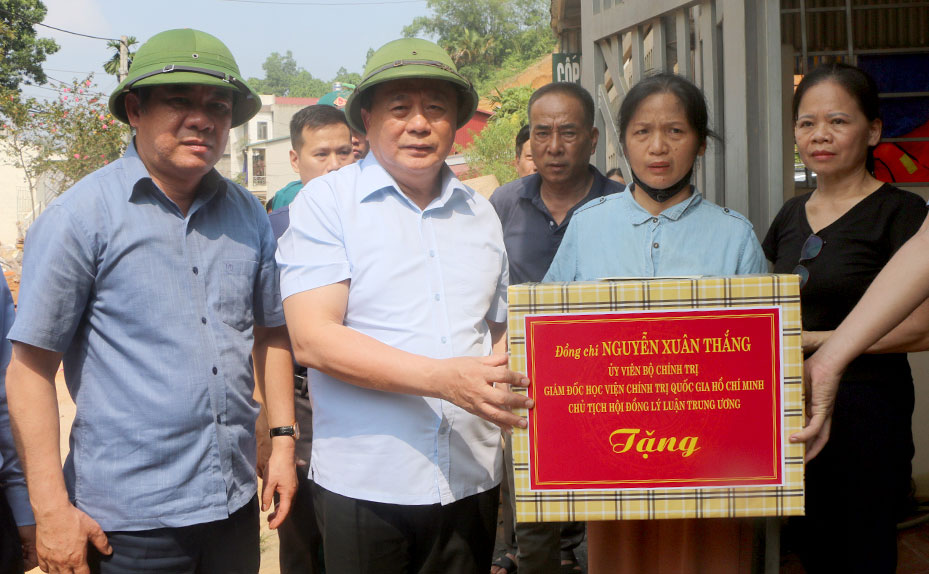 Ong Nguyen Xuan Thang trao ho tro ba Hoang Thi Luan - ho gia dinh co nha bi sap do hoan toan do sat lo dat. Anh: Manh Cuong