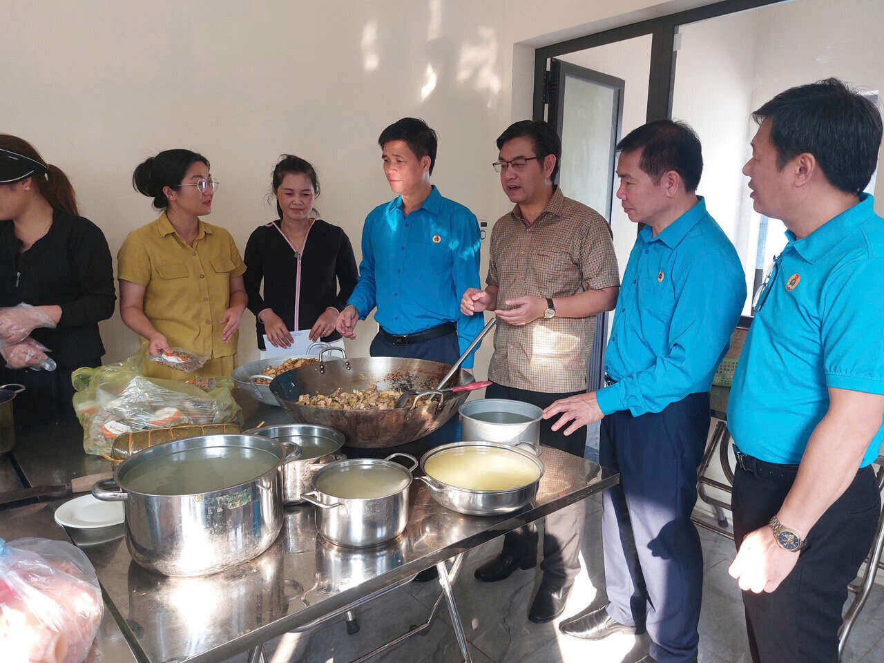 Pho Chu tich Tong LDLDVN Ngo Duy Hieu (thu tu tu phai sang) va Pho Chu tich LDLD Thanh pho Ha Noi Nguyen Huy Khanh (thu 2 tu phai sang) tham cac co giao, nhan vien Truong mam non Nam Phuong Tien to chuc nau an phuc vu nhan dan. Anh: Ngoc Anh