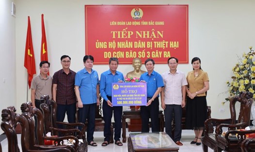 Phó Chủ tịch Tổng LĐLĐVN Huỳnh Thanh Xuân (thứ 4 từ trái qua) trao 500 triệu đồng hỗ trợ đoàn viên, người lao động tỉnh Bắc Giang bị thiệt hại do bão số 3 và lũ lụt. Ảnh: Quyết Chiến