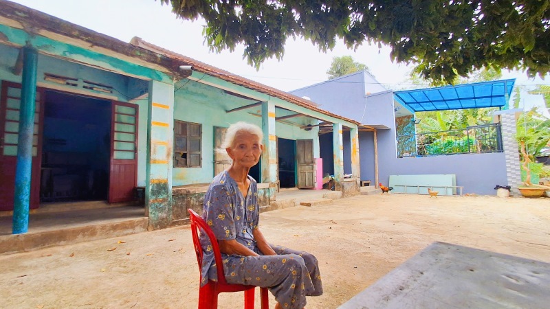 Cụ bà ở làng quy hoạch treo Quảng Nam lộ vẻ lo âu, khi ngôi nhà trái phép của con trai không được cấp sổ đỏ, bắt điện. Ảnh Hoàng Bin