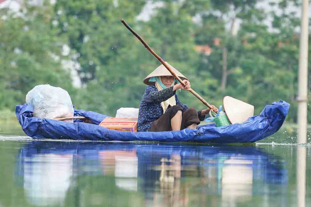 Nước ngập sâu, người dân chỉ có cách dùng thuyền bè để đi lại. Ảnh: Hữu Chánh