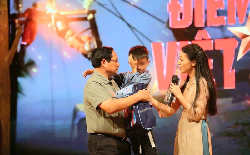 Thủ tướng Chính phủ Phạm Minh Chính động viên, tặng quà cháu Nguyễn Quốc Bảo mồ côi do mưa lũ. Ảnh: Hải Nguyễn