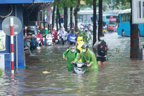 Nhiều tuyến phố ngập sâu đến hết bánh xe khiến các phương tiện di chuyển khó khăn. Ảnh: Việt Anh. 