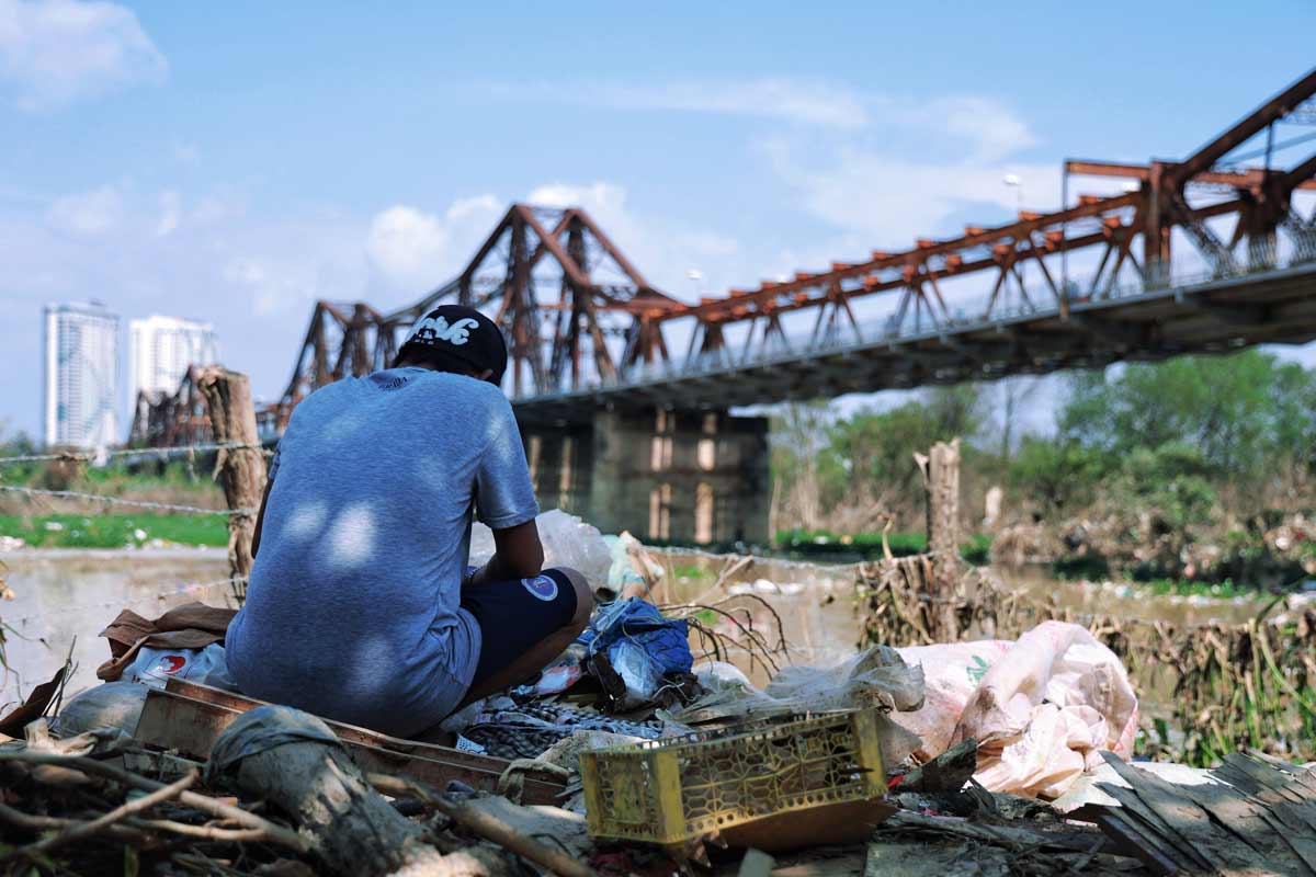 Một người đàn ông lục tìm những thứ còn dùng được trong đống đồ bị ảnh hưởng sau bão.