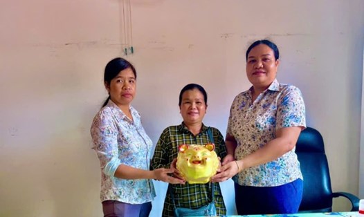 Bà Hồ Thị Thủy đập heo đất, ủng hộ đồng bào bị ảnh hưởng do bão lũ. Ảnh: Đông Tuyết