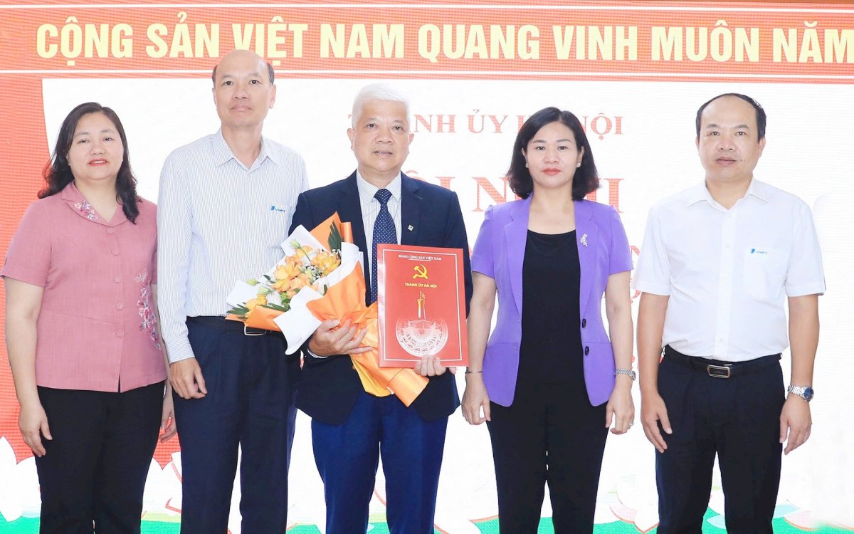 Phó Bí thư Thường trực Thành ủy Hà Nội Nguyễn Thị Tuyến tặng hoa chúc mừng ông Nguyễn Hữu Chỉnh. Ảnh: Quang Thái