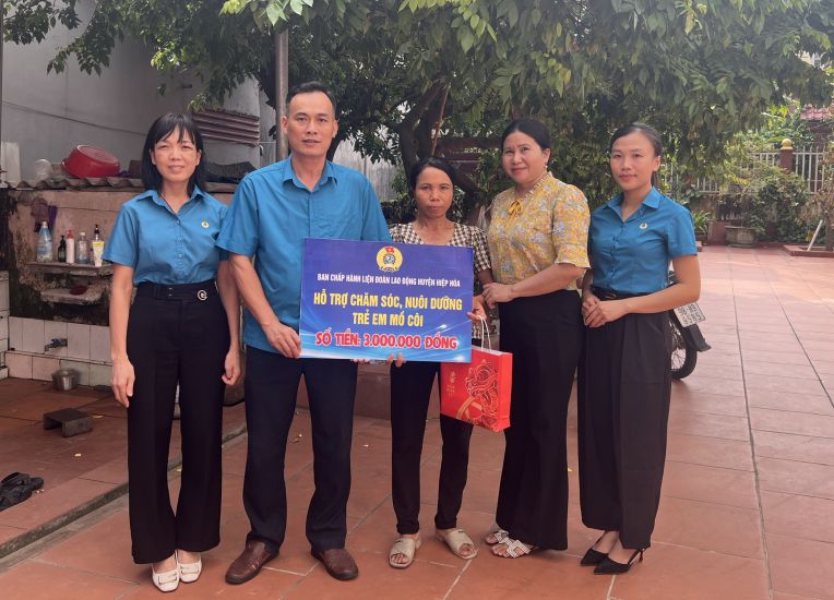 Ông Ngô Quang Tuấn - Chủ tịch LĐLĐ huyện Hiệp Hòa (thứ 2 từ trái qua) trao hỗ trợ chăm sóc, nuôi dưỡng trẻ em mồ côi tới mẹ cháu Trần Thị Mai Hoa. Ảnh: Tạ Hiếu