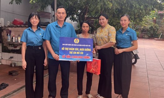 Ông Ngô Quang Tuấn - Chủ tịch LĐLĐ huyện Hiệp Hòa (thứ 2 từ trái qua) trao hỗ trợ chăm sóc, nuôi dưỡng trẻ em mồ côi tới mẹ cháu Trần Thị Mai Hoa. Ảnh: Tạ Hiếu