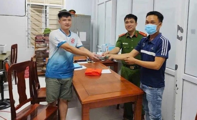 Anh Trương Hoài (ngoài cùng bên phải ảnh) trả lại số tiền nhặt được. Ảnh: Công an xã Triệu Hòa.