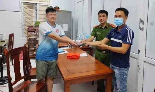 Anh Trương Hoài (ngoài cùng bên phải ảnh) trả lại số tiền nhặt được. Ảnh: Công an xã Triệu Hòa.