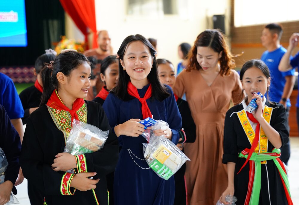 Nhan nhung phan qua gom sua tuoi, sua dac cua Vinamilk va banh mi, cac em deu hon ho, vui thich vi da co the kip don trung thu sau nhung ngay bao lu. Ảnh: Vinamilk