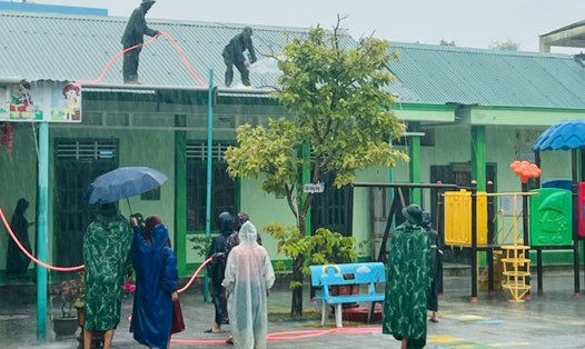 Các lực lượng và cán bộ giáo viên gia cố phần mái trường học trước khi bão số 4 vào.