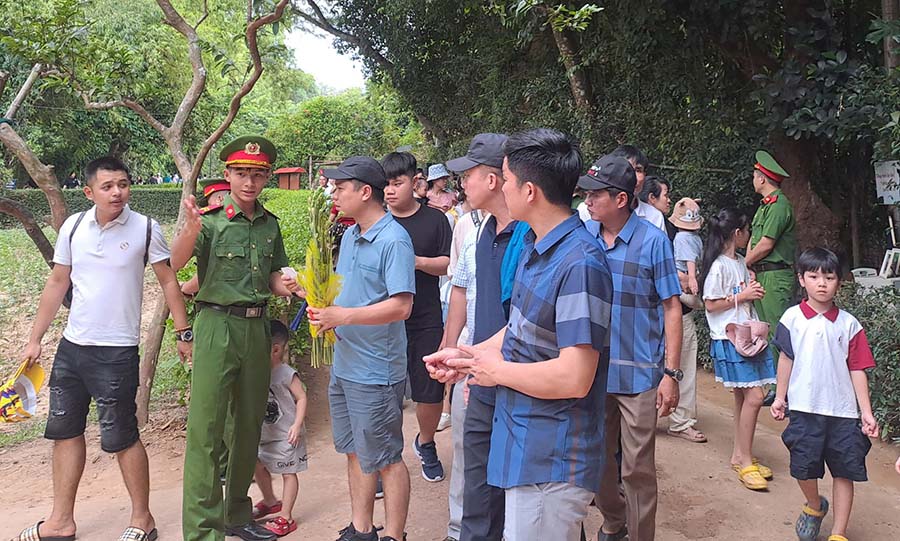 Cán bộ bảo vệ Khu di tích Kim Liên hướng dẫn du khách tham quan. Ảnh: Lê Thủy