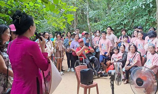 Người dân và du khách về thăm quê Bác dịp Quốc khánh nghe cán bộ thuyết minh giới thiệu về Khu di tích quốc gia đặc biệt Kim Liên. Ảnh: Lê Thủy