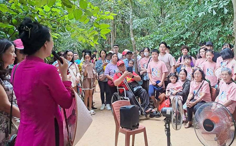 Người dân và du khách về thăm quê Bác dịp Quốc khánh nghe cán bộ thuyết minh giới thiệu về Khu di tích quốc gia đặc biệt Kim Liên. Ảnh: Lê Thủy