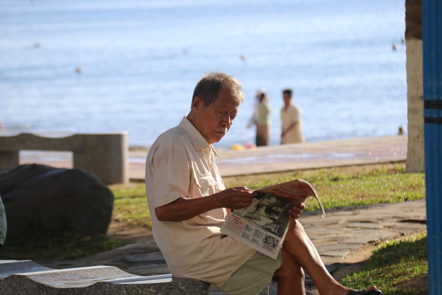 Over 70 years old, today the old man went to the beach early to exercise and leisurely read the newspaper about National Day.