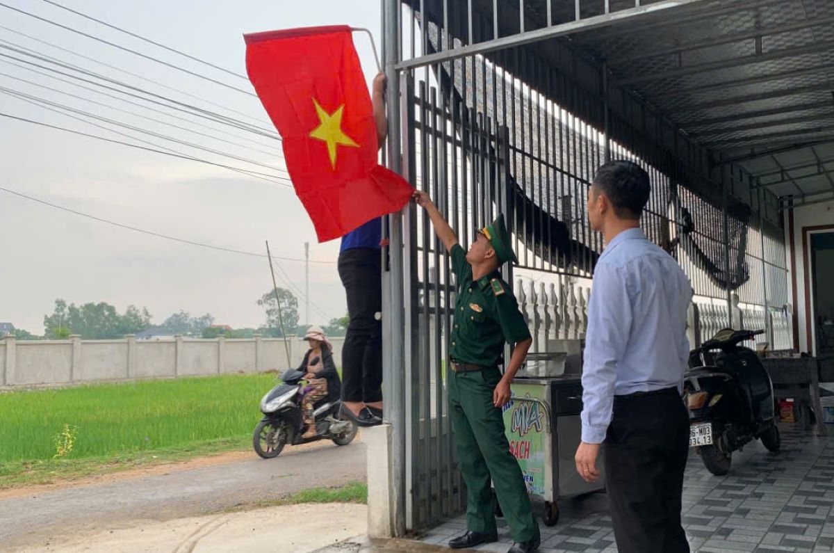 Chiên sĩ Đồn Biên phòng Hải Hòa tặng cờ, cùng bà con giáo dân treo cờ trong Ngày Quốc khánh (2.9). Ảnh: BPTH