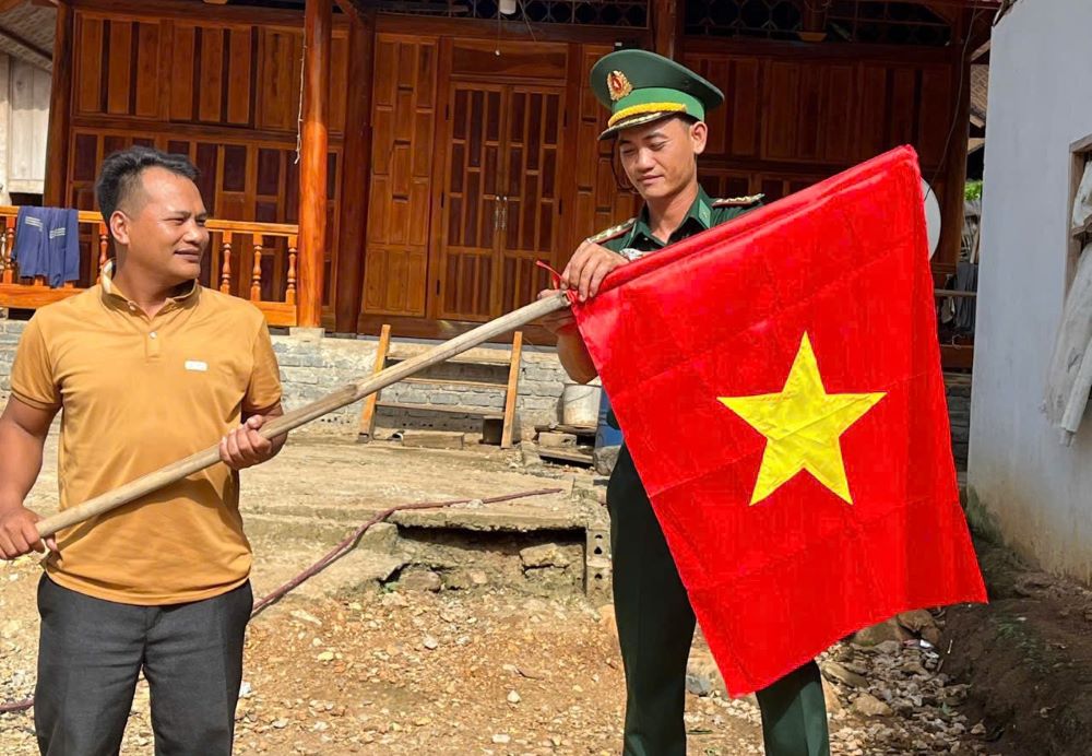 Bộ đội biên phòng giúp dân treo cờ Tổ quốc. Ảnh: BPTH