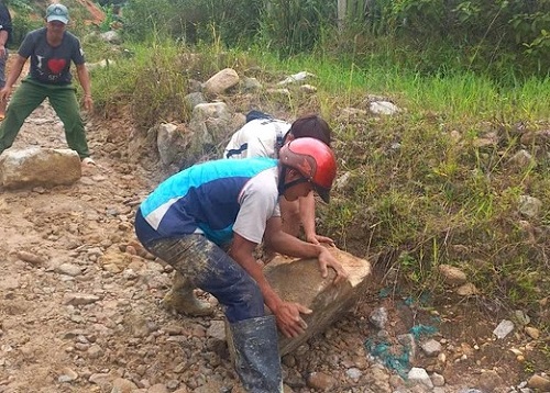 Người dân di dời đá khắc phục sạt lở. Ảnh: Lan Phương 