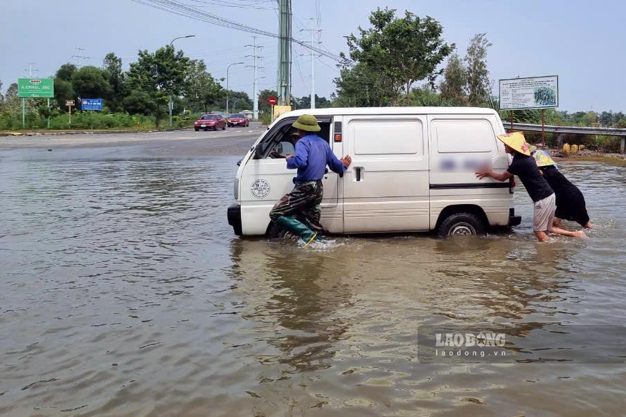 Dịch vụ đẩy xe, kéo xe qua điểm ngập nở rộ mùa mưa bão ở Hà Nội. Ảnh: Tô Thế