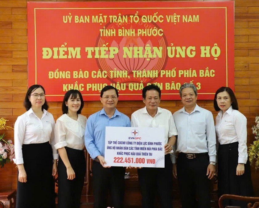 Đại diện Công ty Điện lực Bình Phước (thứ ba từ phải qua) trao tiền của đoàn viên công đoàn, người lao động công ty đóng góp ủng hộ đồng bào miền Bắc bị thiệt hại do bão, lũ lụt gây ra. Ảnh: Đức Long