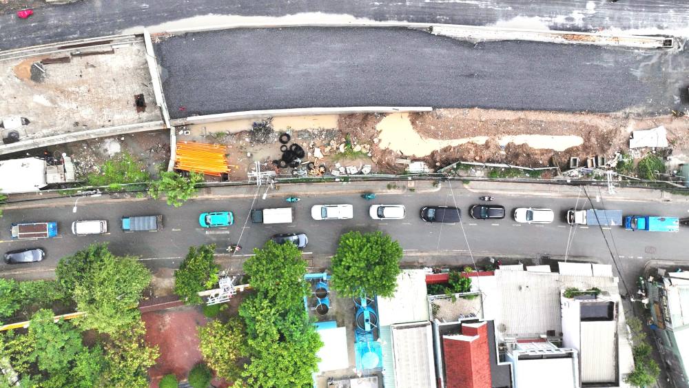 Duong dan len cau hep kem theo mua va cong trinh ke ben nen cac phuong tien luu thong qua cau Phuoc Long cu di chuyen cham, gay un u. Anh: Anh Tu