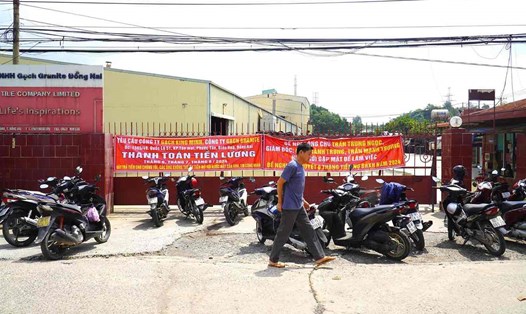 Công nhân trước cổng Công ty TNHH Gạch granite Đồng Nai yêu cầu trả nợ lương, chốt bảo hiểm. Ảnh: HAC