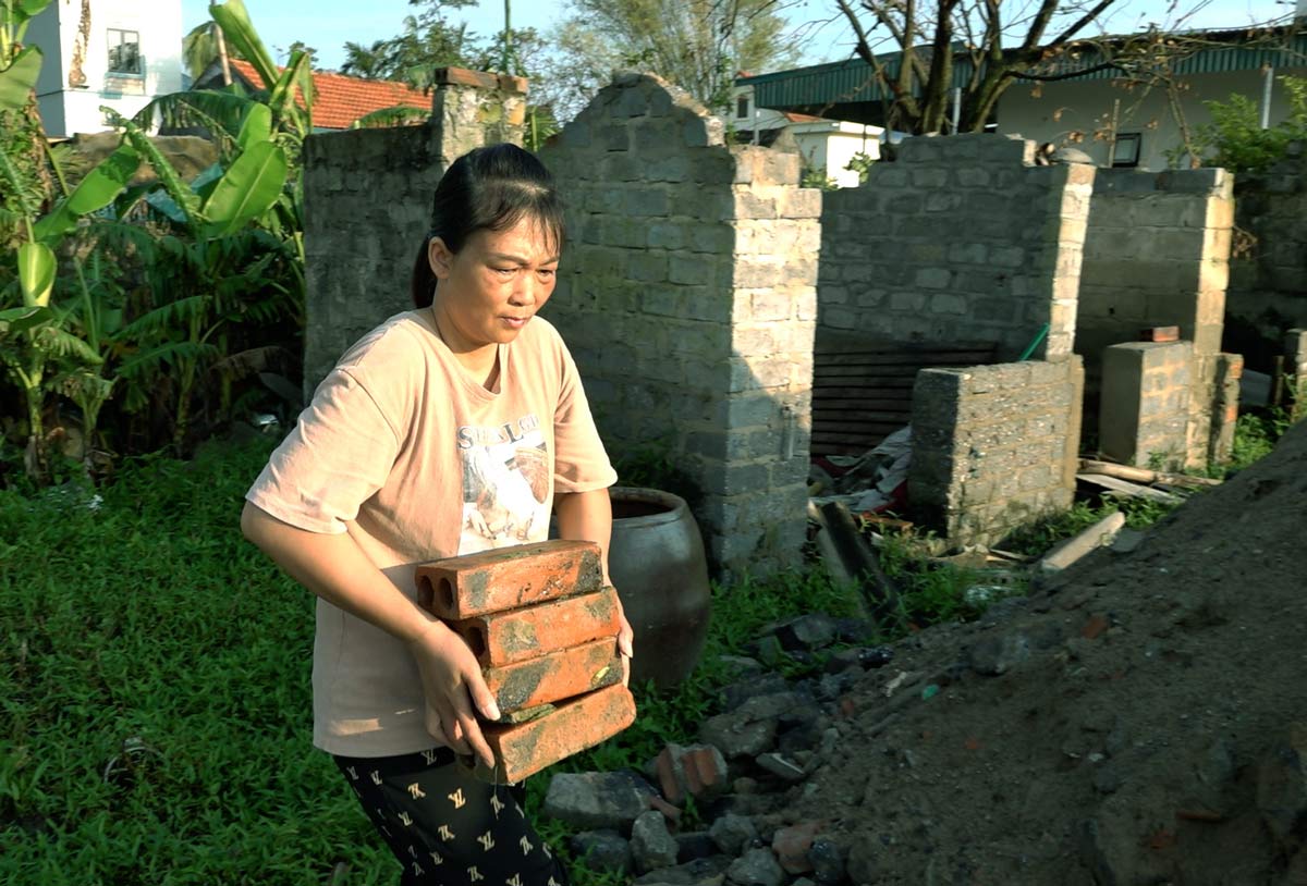 Chị Vũ Thị Thắm, thôn Giếng Méo, xã Tiền An, TX Quảng Yên, tỉnh Quảng Ninh đang tận dụng lại những viên gạch đỏ từ ngôi nhà bị hư hỏng của gia đình sau bão. Ảnh: Đoàn Hưng
