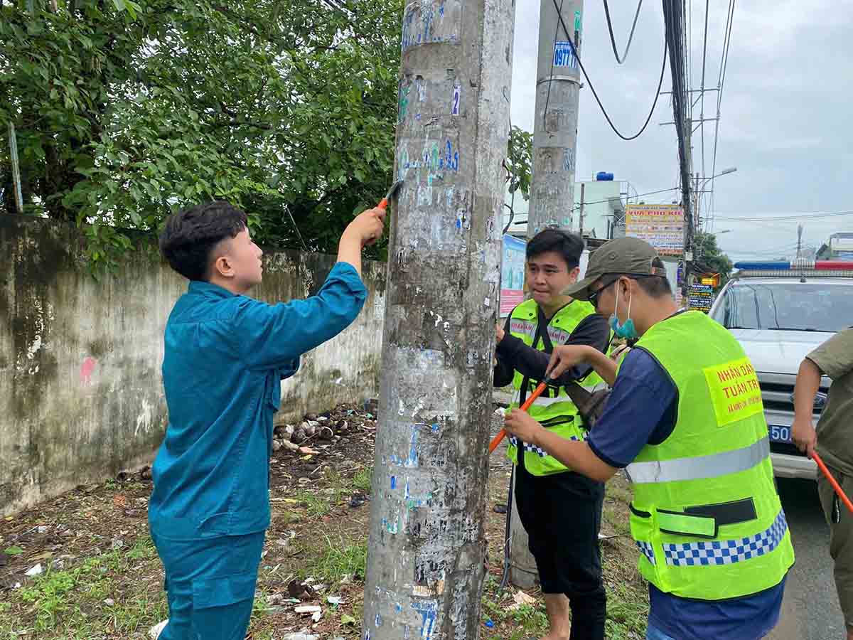 Các lực lượng chức năng bóc xóa các sản phẩm quảng cáo sai quy định. Ảnh: Công an cung cấp