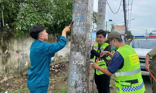 Thanh niên TPHCM ra quân xóa quảng cáo bẩn. Ảnh: Công an cung cấp