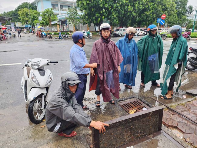 Phong Quan ly do thi TP Quang Ngai kiem tra cac cong thoat nuoc ngay trong luc mua de danh gia hien trang ngap nuoc quanh khu vuc Benh vien Da khoa tinh Quang Ngai. Anh: Vien Nguyen