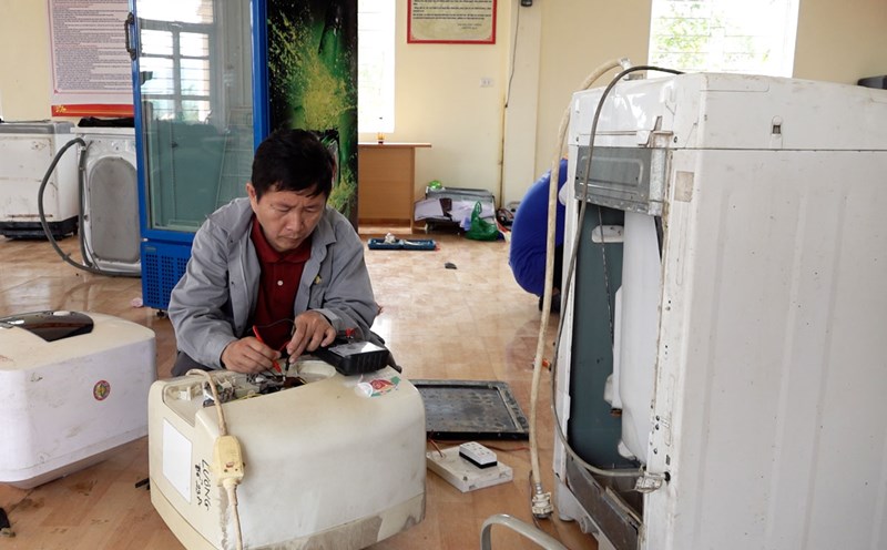A teacher in a volunteer group is repairing water heaters for people in flooded areas in Quang Ninh. Photo: Doan Hung