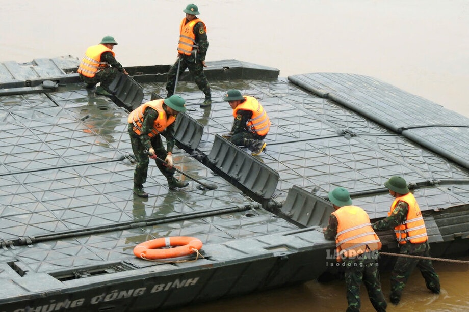 Tại bến sông thuộc địa phận khu 5, xã Hương Nộn, các cán bộ chiến sĩ đang lắp đặt thử nghiệm 3 nhịp cầu phao ở gần bờ sông.