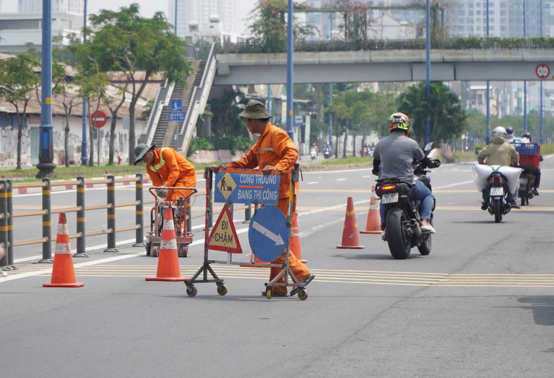 Hien chi co mot nhom cong nhan nho thuc hien cong doan cuoi cung xoa bo nhung vach ke duong cu.