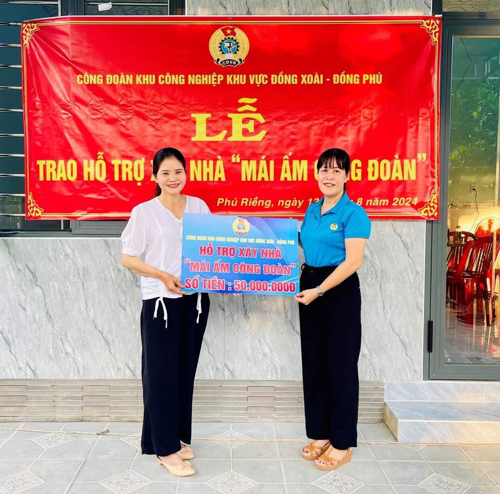 Dong chi Ngo Thi Yen, UV.BTV LDLD tinh, Chu tich Cong doan KCN KV Dong Xoai - Dong Phu trao bang tuong trung so tien ho tro xay nha “Mai am cong doan” cho doan vien Nguyen Thi Huong. Anh: Bui Van Son