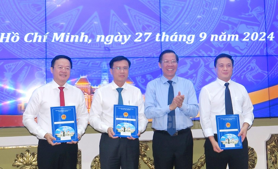 Chu tich UBND TPHCM Phan Van Mai trao quyet dinh ong Dinh Khac Huy, ong Nguyen Minh Nhut va ong Nguyen Trung Anh.  Anh: Minh Hiep