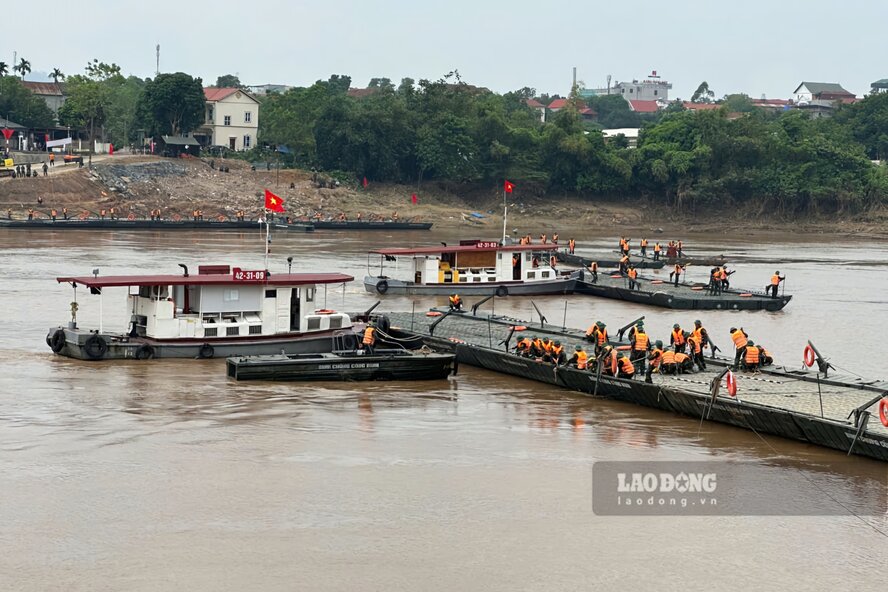 Cac dot khoi duoc noi ghep lai va co dinh voi nhau de tao thanh chiec cau phao hoan chinh. Anh: To Cong.