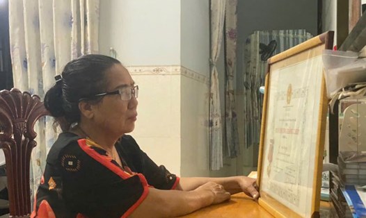 Bà Nguyễn Thị Cúc bên Huân chương Kháng chiến hạng Ba của mẹ. Ảnh: Hưng Thơ