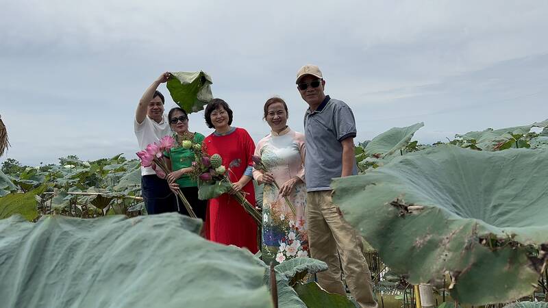 Du khách trải nghiệm cùng ao sen nở muộn tại Quốc Oai, Hà Nội. Ảnh: Hoàng Lộc