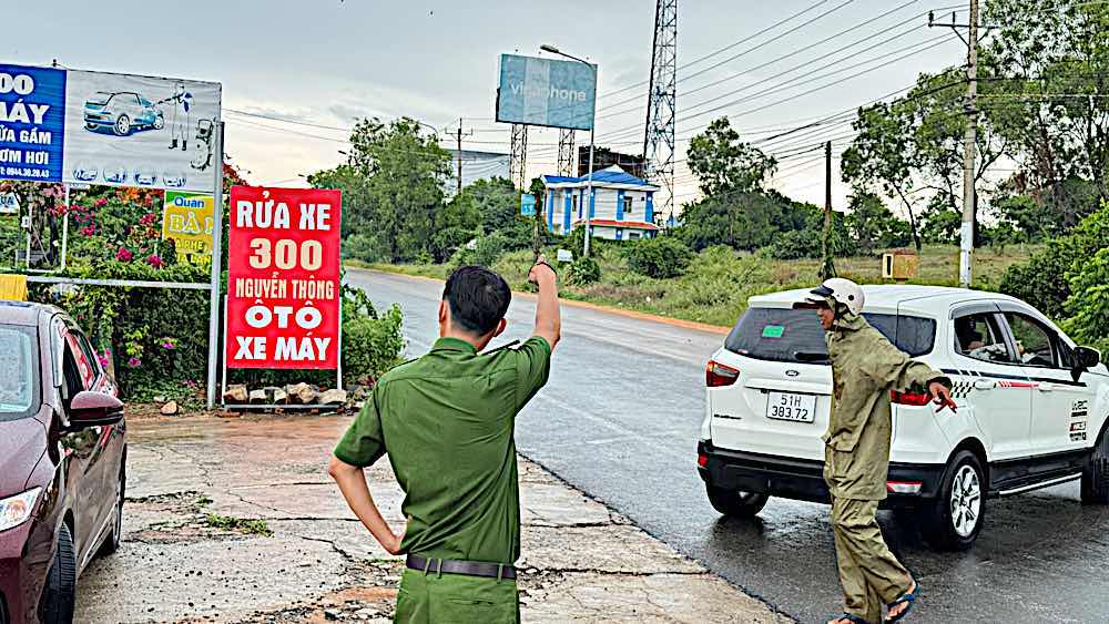 Công an hướng dẫn các ôtô chạy đường khác để tránh bị lún. Ảnh: Duy Tuấn 