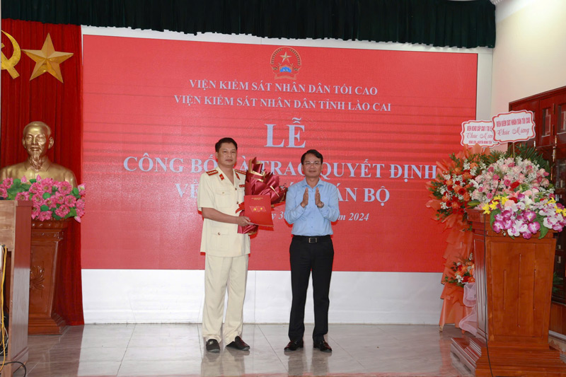 Bí thư Tỉnh ủy Lào Cai Đặng Xuân Phong trao quyết định và tặng hoa chúc mừng tân Viện trưởng Viện Kiểm sát nhân dân tỉnh. Ảnh: Đinh Đại