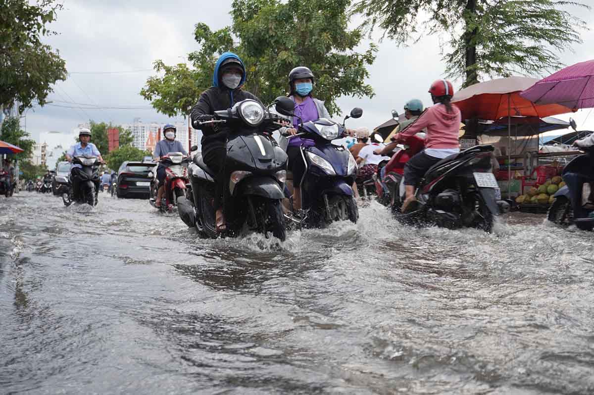 Triều cường khiến đường Trần Xuân Soạn ngập, cuộc sống của người dân bị ảnh hưởng. Ảnh: Như Quỳnh