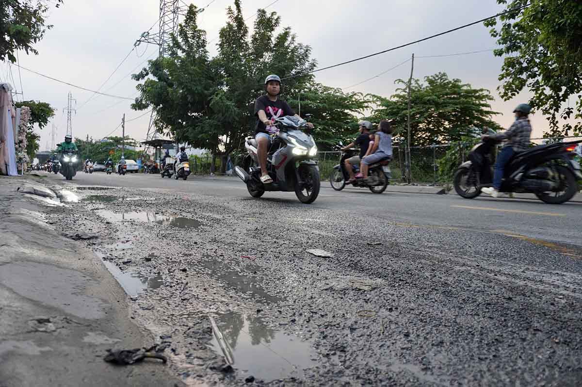 Do thường xuyên bị ngập do triều cường, mặt đường Trần Xuân Soạn bị bong tróc . Ảnh: Như Quỳnh