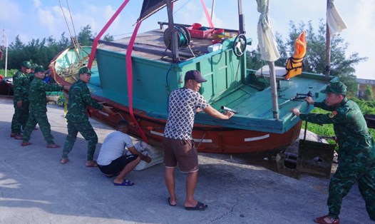 Cán bộ, chiến sỹ Đồn Biên phòng Bạch Long Vĩ giúp ngư dân đưa tàu cá lên bờ tránh bão số 3. Ảnh: Sơn Hà