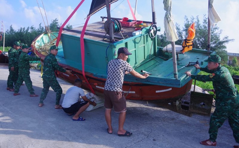 Cán bộ, chiến sỹ Đồn Biên phòng Bạch Long Vĩ giúp ngư dân đưa tàu cá lên bờ tránh bão số 3. Ảnh: Sơn Hà