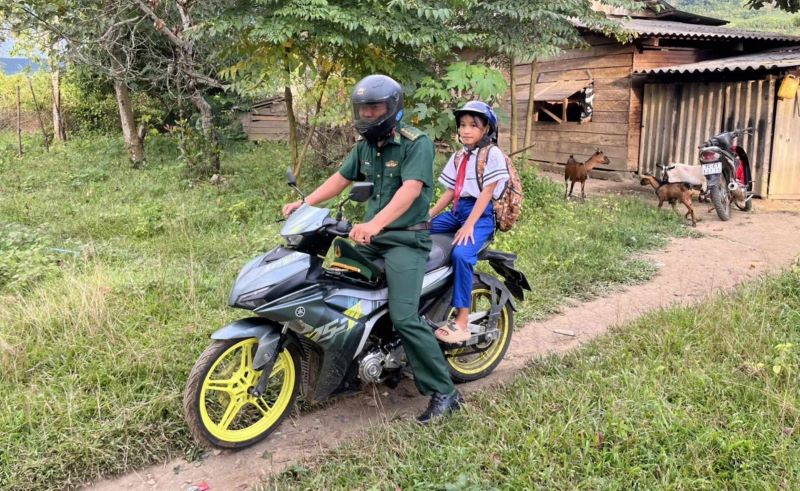 Border guards take a girl who lives in the Vietnam-Laos border area to school in time for the opening ceremony of the new school year. Photo: Phan Vinh.