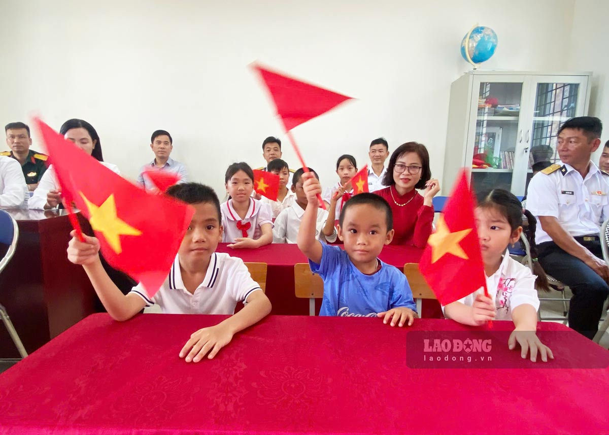 Lá cờ tổ quốc được các em nâng cao đầy thành kính, trang nghiêm và xúc động. Ảnh: Thu Báu
