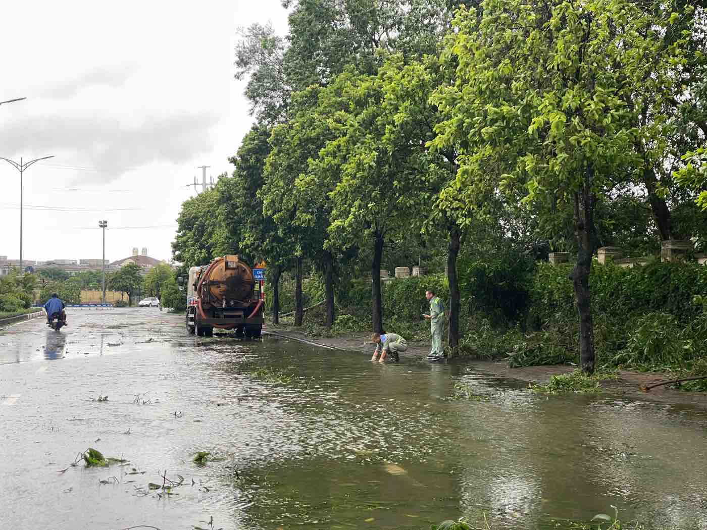 Công nhân thực hiện tiêu thoát nước tại các khu vực ngập úng. Ảnh: Hoài Anh