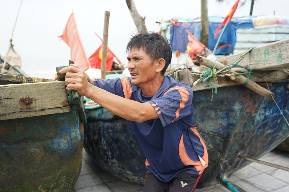 Các ngư dân ở thành phố biển Sầm Sơn hối hả đưa thuyền lên bờ, gia cố cẩn thận trong sáng và trưa 6.9. Ảnh: Quách Du